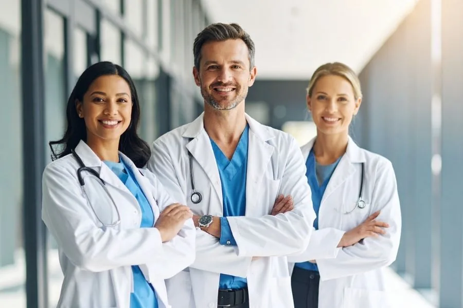 Three clinicians in white coats